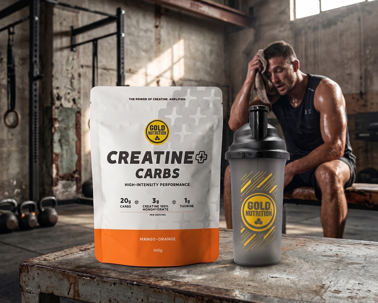 EN: Gold Nutrition "Creatine + Carbs" supplement package and shaker bottle on a table in an industrial gym.

PT Embalagem de suplemento e coqueteleira Gold Nutrition "Creatine + Carbs" sobre uma mesa num ginásio industrial.

ES: Paquete de suplemento y mezclador Gold Nutrition "Creatine + Carbs" sobre una mesa en un gimnasio industrial.

FR: Sachet de supplément et shaker Gold Nutrition "Creatine + Carbs" sur une table dans une salle de sport industrielle.